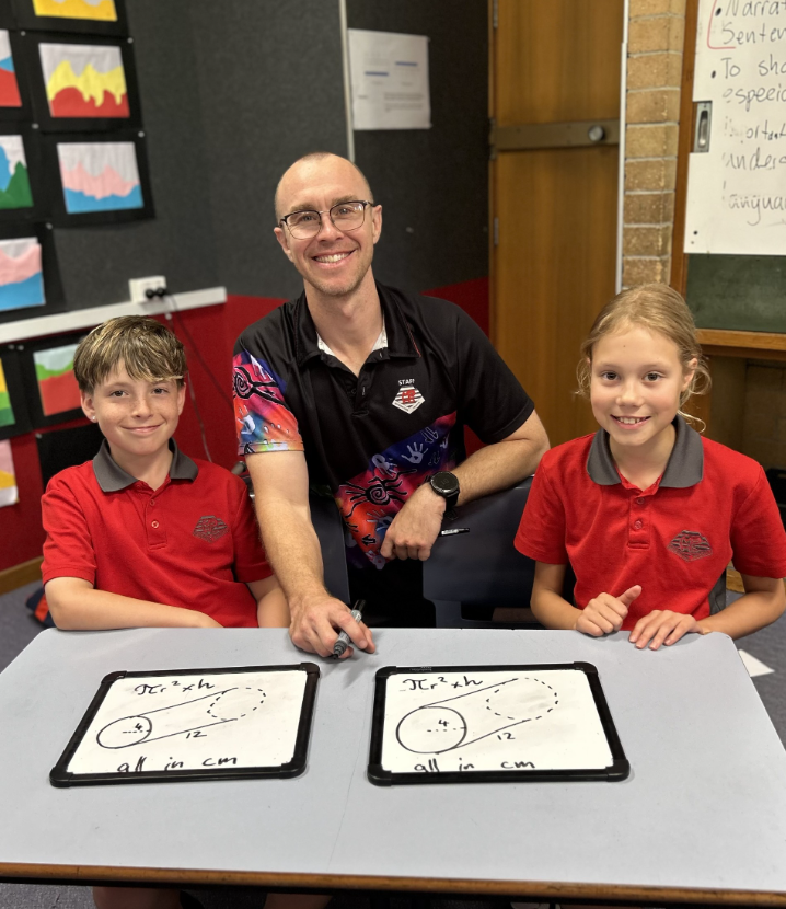 Photo of Mr Casserly working with two students.
