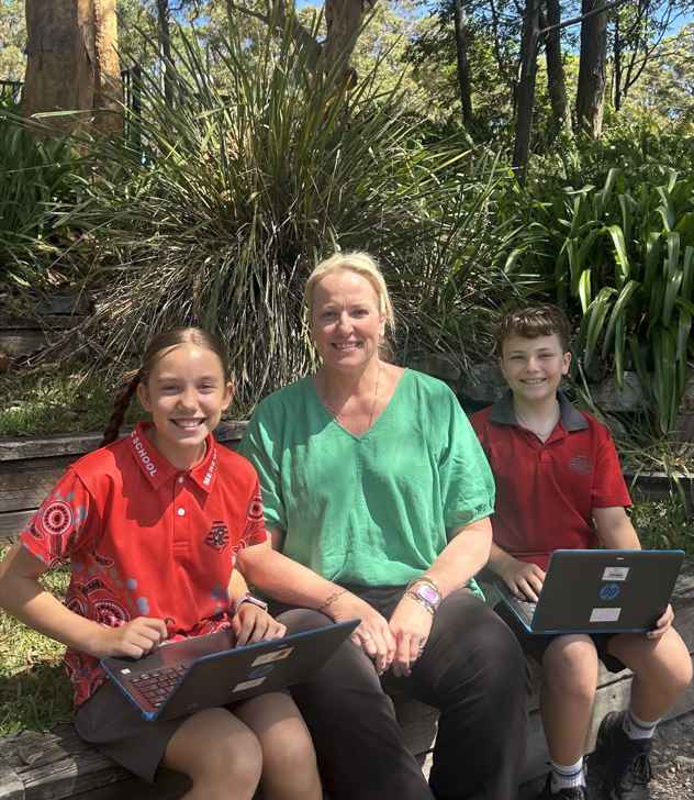 Photo of Mrs Hannah working with 2 students.